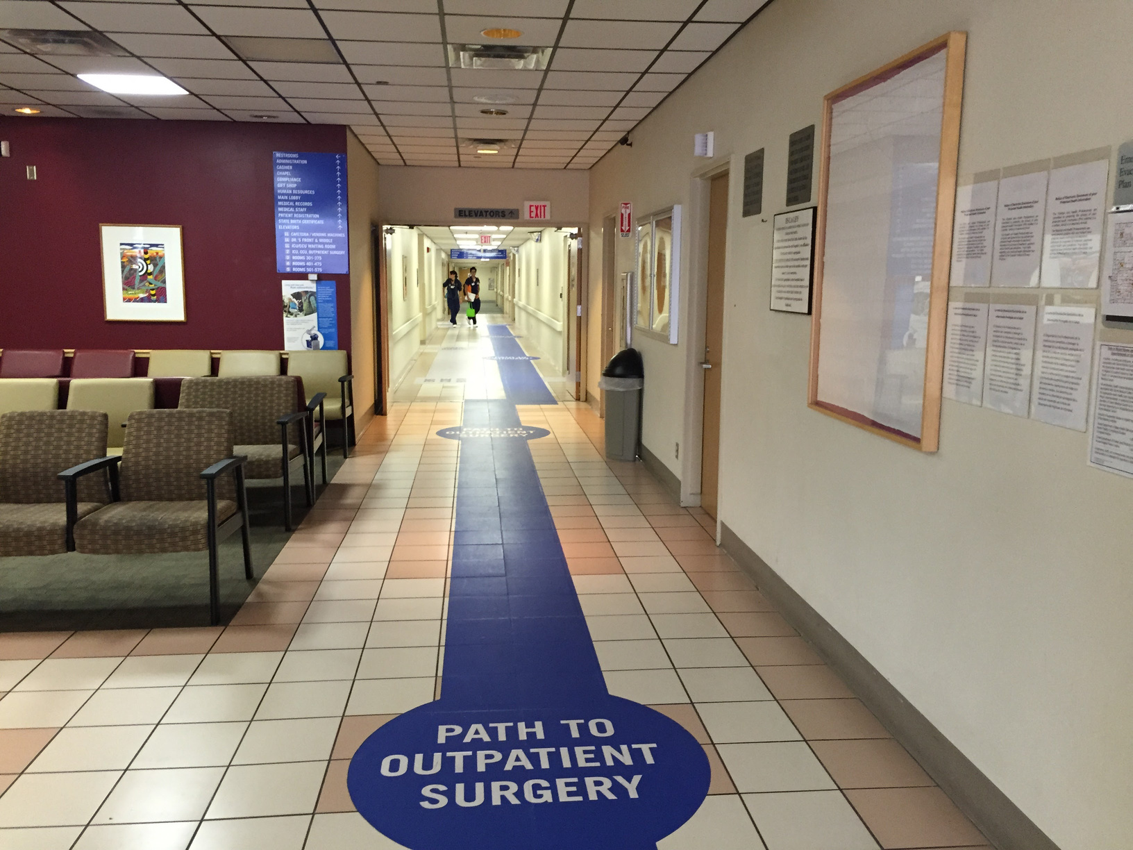 A VA hallway with a large blue floor path directing patients to outpatient surgery